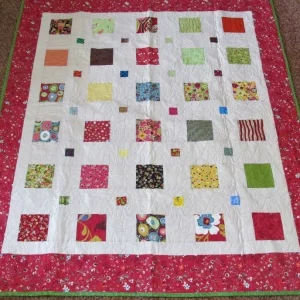 red bordered quilt with geometric squares