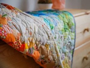 quilt on top of wood dresser