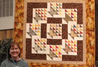 Barbara Derby created "Fall Baskets" from Block of the Month basket blocks that she won many years ago. She quilted it on a long arm at Quilt Crossing - her first! The pattern is "Circle of Nine" by Janet Houts & Jean Ann Wright.