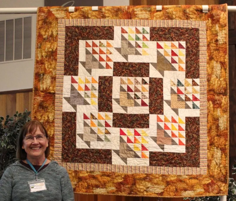 Barbara Derby created "Fall Baskets" from Block of the Month basket blocks that she won many years ago. She quilted it on a long arm at Quilt Crossing - her first! The pattern is "Circle of Nine" by Janet Houts & Jean Ann Wright.
