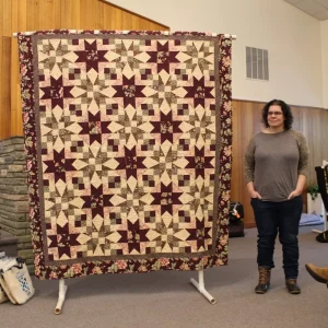 Danielle Alba made this quilt for her husband's niece for her July wedding. She used a kit from Craftsy and is her largest project to date. This was her first time making star blocks and using free motion quilting. Her husband helped too. Lucky Bride!