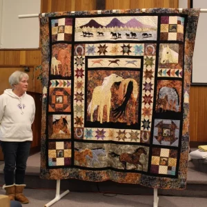 Ann Davis made Horsing Around using a kit from Prairie Girls Quilt Shop in Prineville OR. She recently bought a new sewing machine and applied new skills on this quilt for her daughter: ruler quilting, embroidery, stitch regulator, walking foot, applique and piecing.