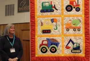 Kathy made this quilt for her newest grandson, Paul Donovan Schloss. She teased his brother for months that the baby's name was going to be Bartholomew. It is machine appliqued and hand quilted. The pattern is "I love Dirt."