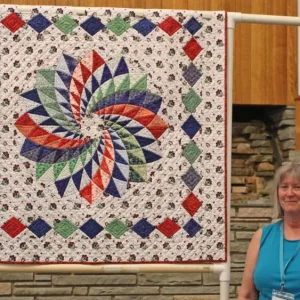 Kathy England took a class in about 2010 on curved piecing using glue technique at Quilt Crossing. She finished the machine piecing quickly but just finished the HAND quilting this year. Expandnext