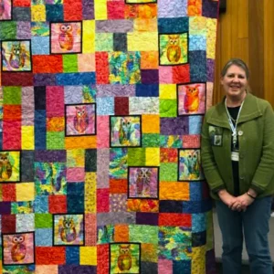 Jan Lundine was inspired to make her quilt by the sound of several Great Horned Owls. She designed it and this was the first time she used free motion quilting on a long arm. It is a birthday present for her husband.